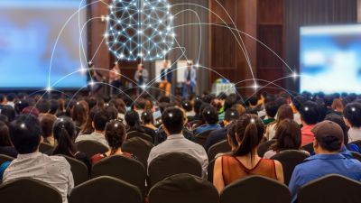 Large crowd at a business event panel discussion
