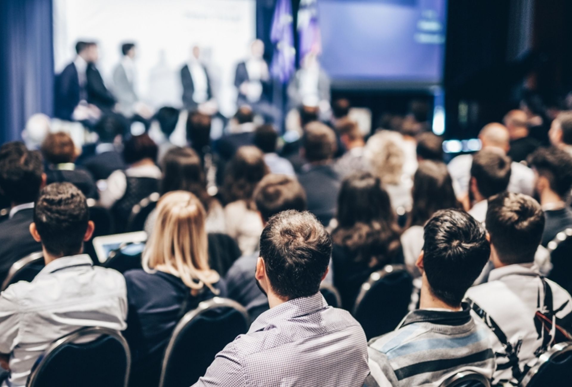 Large crowd at a business event panel discussion